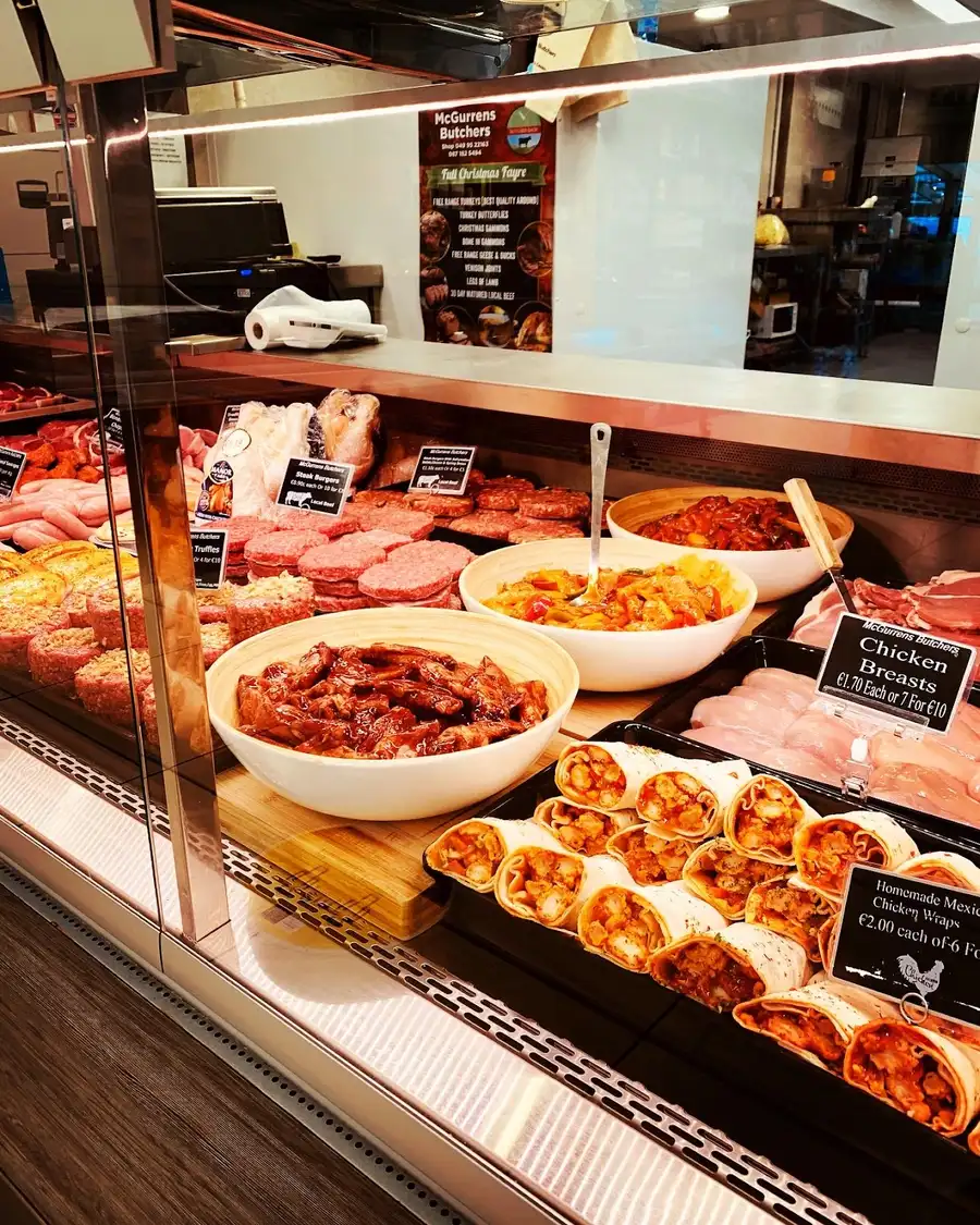 Cooked foods counter with homemade wraps, chicken breasts and prepared dishes