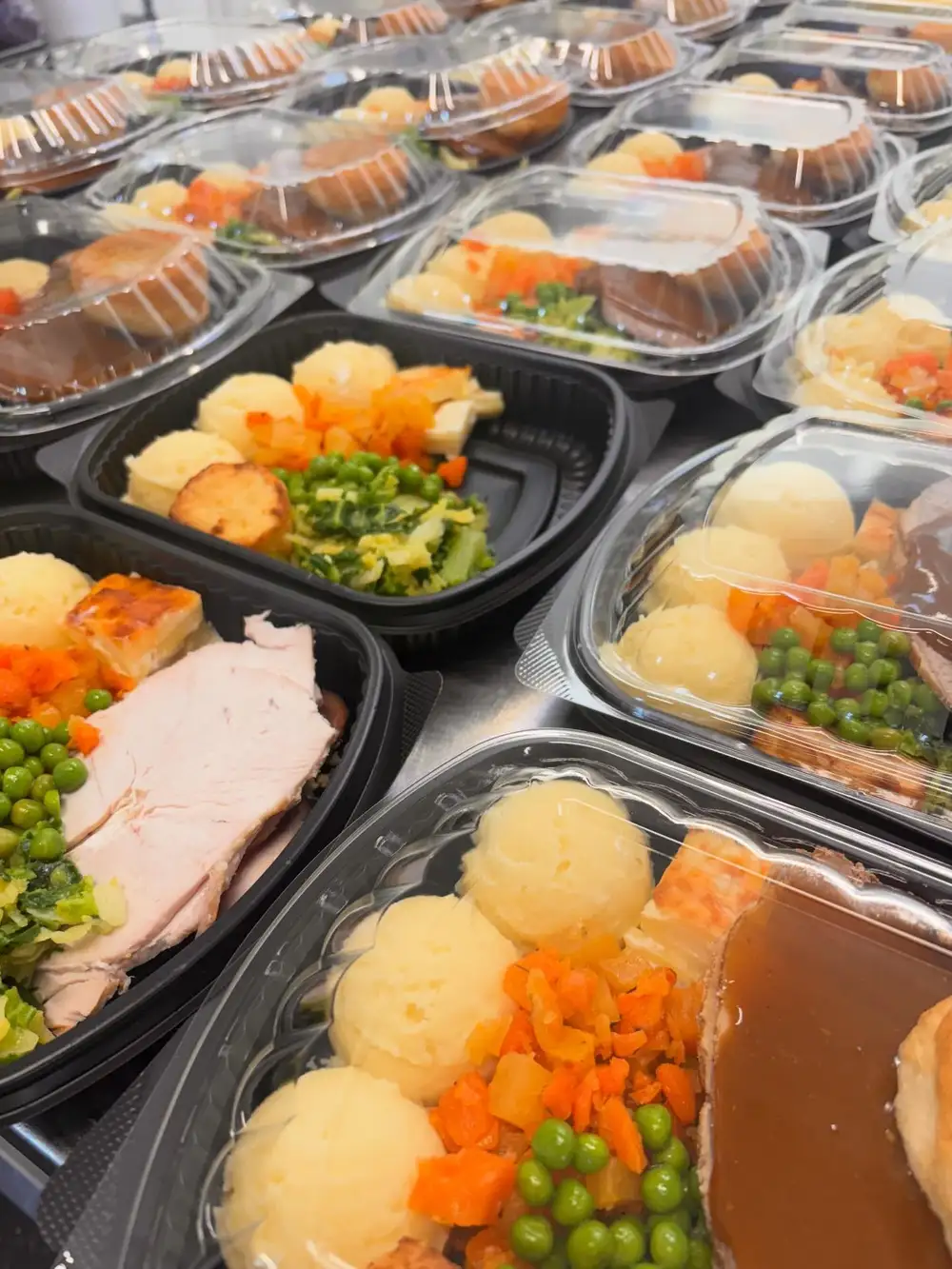 Packed and lidded ready meals stacked for the fridge